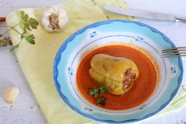 Stuffed bell peppers whit rice and minced meat and mash potatoes served on white wooden background/ Traditional Balkan cuisine/