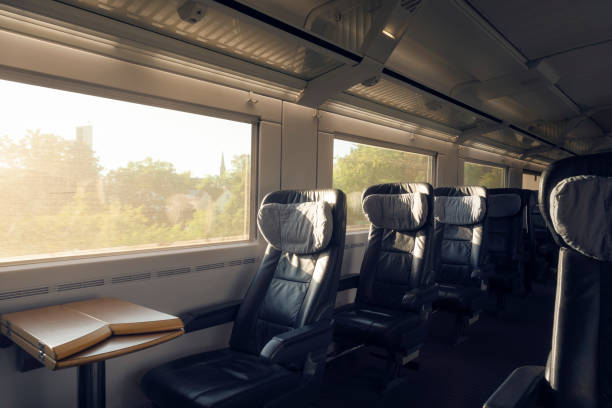 Train interior with empty seats traveling in Germany. Intercity express train with no people First-class train interior with empty seats, in motion, on sunny day. Passenger train, a german intercity express. Public transport in business class train interior stock pictures, royalty-free photos & images
