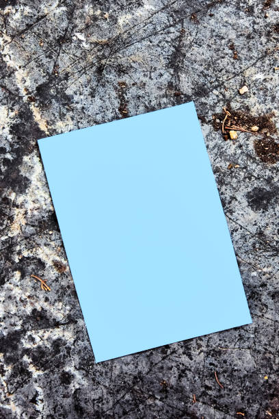 istock Blank empty blue paper mock up on a rock background in nature. 1284857733