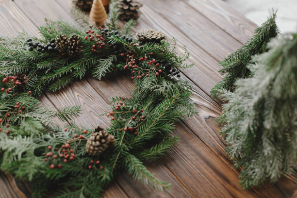 istock Modern christmas wreath with berries, pine cones, natural tree decorations on rustic background 1284858145