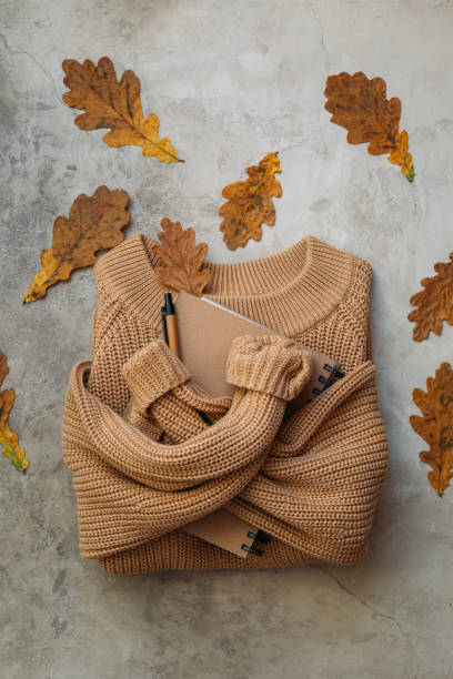 istock Autumn composition. Sweater, notebook and pen on stone background. Flat lay with copy space 1284861232