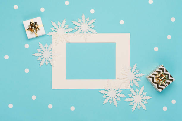istock Empty frame, snowflakes, gifts, festive decorations on pastel blue background. Christmas, winter, new year concept. 1284862859