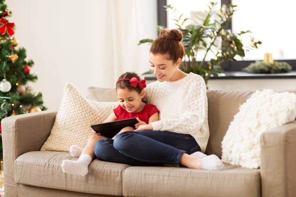 istock mother and daughter with tablet pc at christmas 1284864812