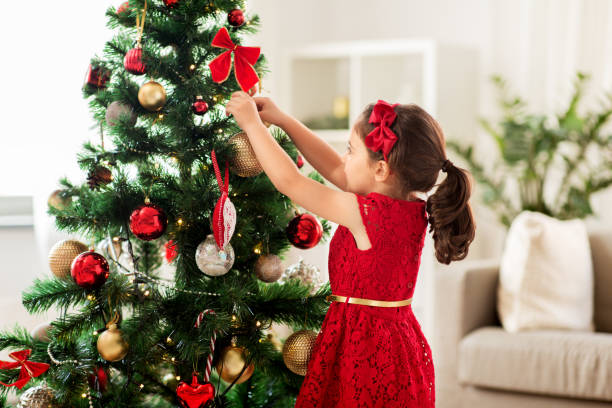 istock little girl decorating christmas tree at home 1284864826