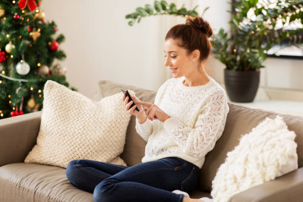 istock woman with smartphone at home on christmas 1284864836