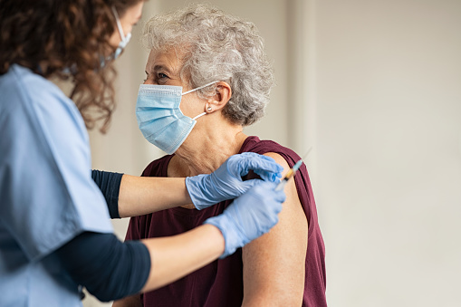 Médico dando vacuna de Covid a la mujer de la tercera edad photo