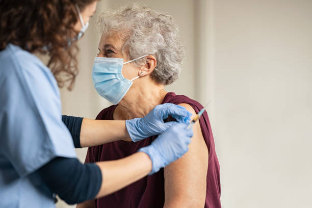 docteur donnant le vaccin de covide à la femme âgée - patient doctor hospital senior adult photos et images de collection