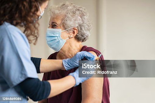 istock Doctor giving Covid vaccine to senior woman 1284869084