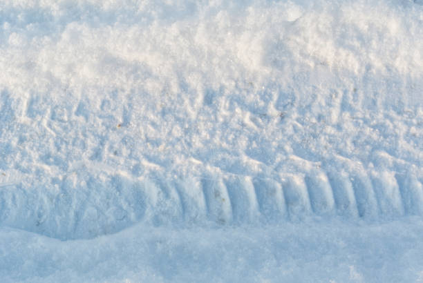 istock Car tire tracks on snow close-up 1284871395