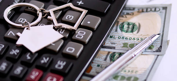 istock House model key with dollars and calculator on white table 1284874412