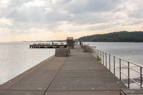 istock Long concrete pier with wooden benches.. 1284878323