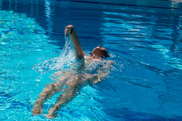 istock Woman Swimming in a Swimming Pool with Sunlight 1284880643