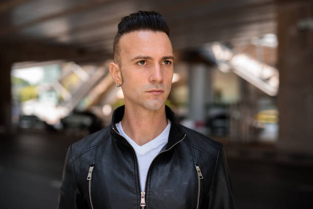 istock Face of handsome young Italian man with undercut wearing black leather jacket outdoors while thinking 1284880963