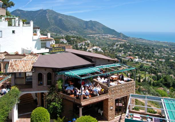 Terrace restaurant overlooking the countryside, Mijas, Spain. Tourists relaxing at a restaurant with a panoramic view of the coast and Mediterranean sea, Mijas, Spain. mijas pueblo stock pictures, royalty-free photos & images