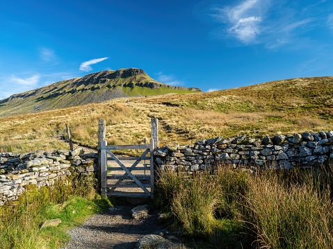 Steep paths and gates lead up to Pen-y-ghent mountain in the Yorkshire Dales. England