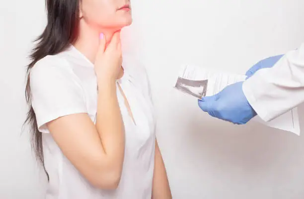 Photo of The doctor holds the results of examination of the girl's throat in his hands. Concept of symptoms and sore throat in coronavirus. Reinfection COVID-19, pain