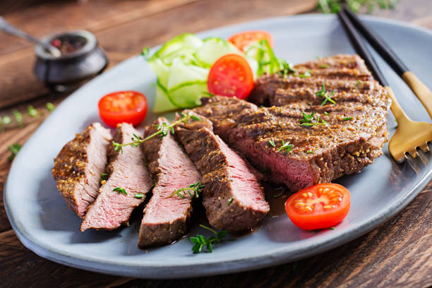 istock Grilled juicy steak medium rare beef with spices and fresh salad. 1284885721