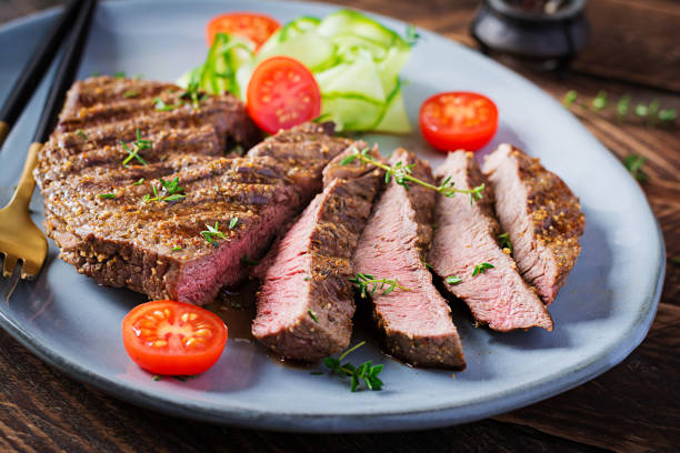 istock Grilled juicy steak medium rare beef with spices and fresh salad. 1284885725