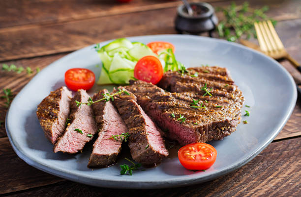istock Grilled juicy steak medium rare beef with spices and fresh salad. 1284885727