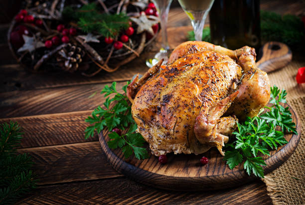 istock Baked turkey or chicken. The Christmas table is served with a turkey, decorated with bright tinsel. Fried chicken, table setting. Christmas dinner. 1284885809