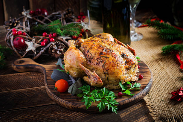 istock Baked turkey or chicken. The Christmas table is served with a turkey, decorated with bright tinsel. Fried chicken, table setting. Christmas dinner. 1284885821