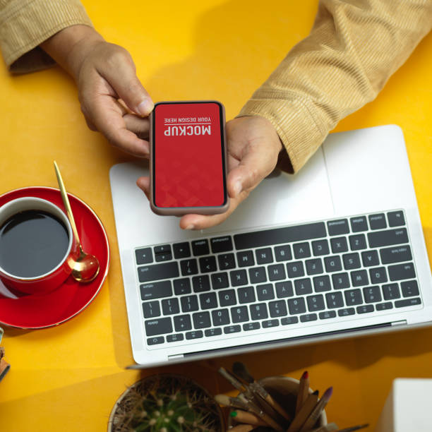 istock Male hands using smartphone with laptop and coffee cup on the table, clipping path 1284885908