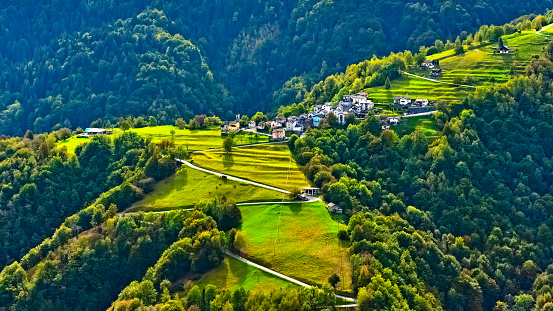 the municipality of Moneto in Centovalli with its wooded surroundings and a road in autumn. The Centovalli is a valley in the Swiss canton of Ticino with a densely wooded landscape.