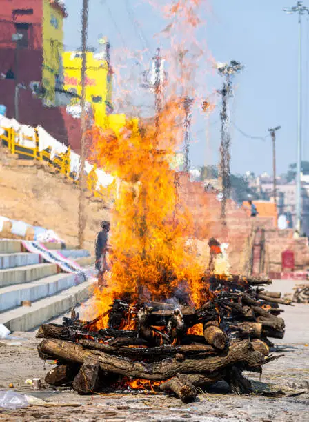 a pyre is burning on harishchandra ghat in banaras.