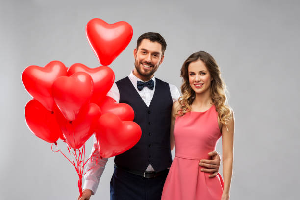 istock happy couple with red heart shaped balloons 1284888426