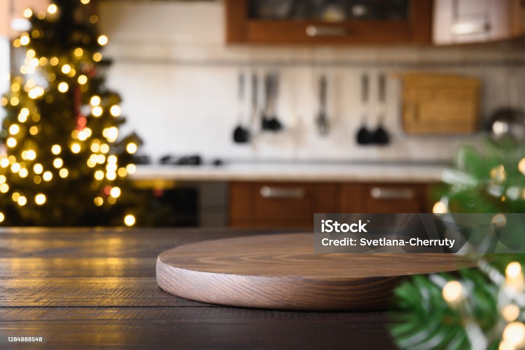 Wooden Tabletop With Cutting Board And Blurred Modern Kitchen With Christmas  Tree Stock Photo - Download Image Now - iStock