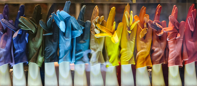 A row of colorful fashionable finger-gloves, made of soft leather. Seen outside a Belgian shop