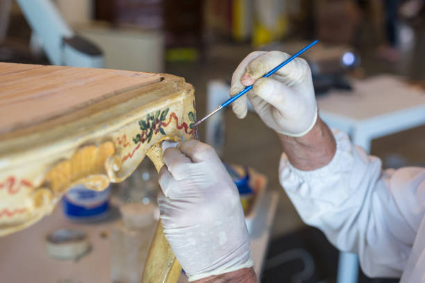 mani di un restauratore con guanti e pennello: lavorare sul restauro di una sedia - restaurazione foto e immagini stock