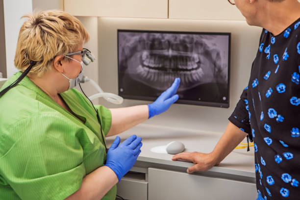 a female dentist consulting with a patient in a dental surgery - dentist office nurse doctors office blond hair imagens e fotografias de stock