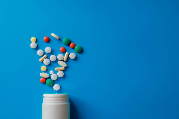 haufen von pillen auf blauem hintergrund verschiedene pharmazeutische arzneimittel pillen, tabletten und kapseln und flasche auf blauem hintergrund. - tablette fotos stock-fotos und bilder