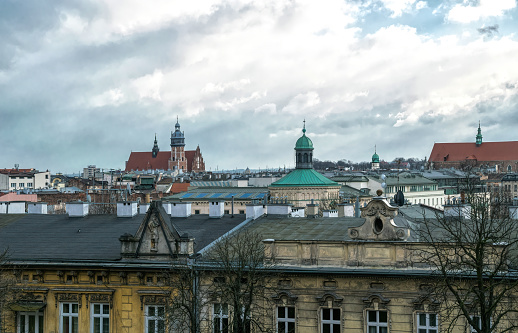 Krakow, Poland - November 30, 2019: Winter city panorama of old Gothic Krakow outside the walls of the Wawel Castle. Overhanging snow clouds and the ancient architecture of the Catholic churches and residential buildings of the Old Town. Tourist trip to Poland
