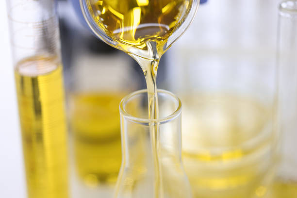 istock Golden liquid is poured from flask into test tube. 1284897417