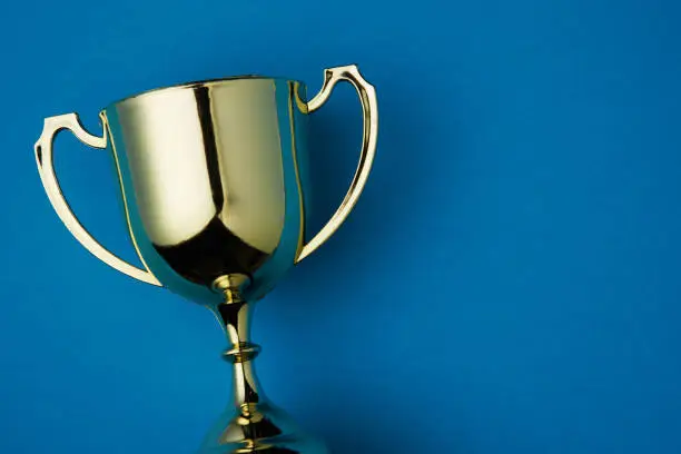 Photo of golden trophy on blue background