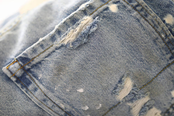 istock Back pocket of jeans with frayed and thread. 1284897565