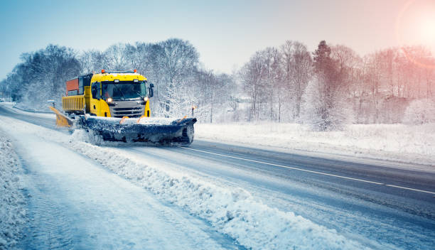 schneepflug-lkw räumt schneebedeckte straße nach schneesturm. - blizzard ice damaged snow stock-fotos und bilder