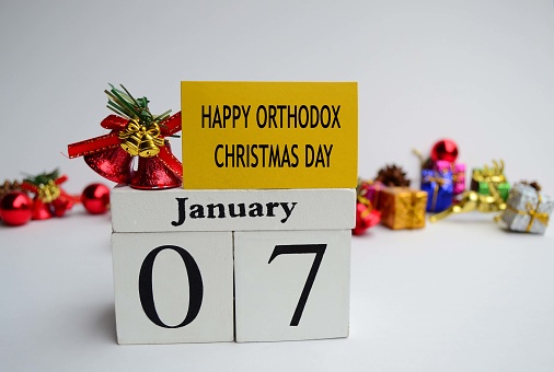 Text label and cube 7th January with blurred christmas ornament background, Happy Orthodox Christmas Day - Christmas Celebrations