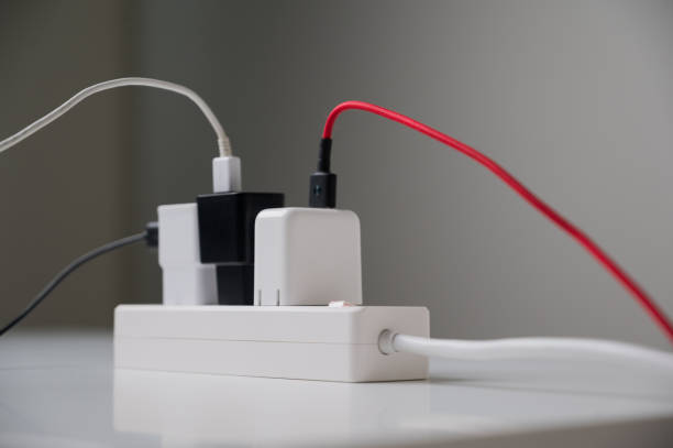 istock Electric adapter smartphone plug in multiple socket. Electrical equipment, electrical wires and power strips in the house. Earth Hour saving electrical energy. 1284898732