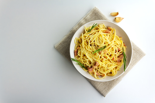 Carbonara pasta. Spaghetti with fried brisket or bacon with egg parmesan sause and spices. Traditional italian cuisine. Flat lay with copy space