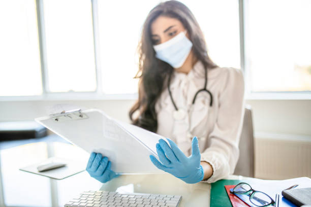 istock Young female doctor working in her office, using computer and reading medical documents 1284900389