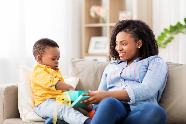 happy mother and baby with open gift box at home