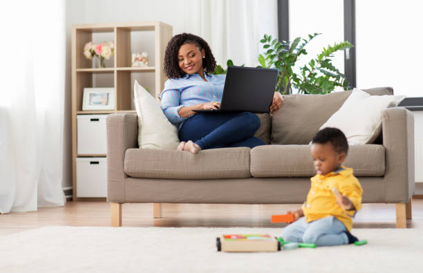 istock mother with laptop looking at baby with toy blocks 1284901452