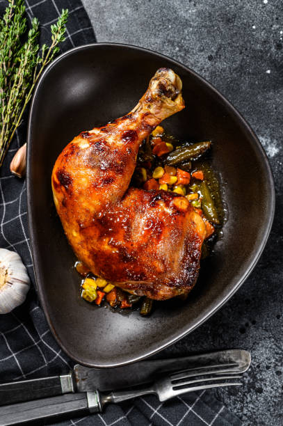 istock Cooked roasted chicken legs. Grilled meat. Blacked background. Top view 1284903273
