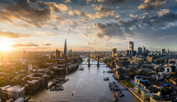 Panoramic view to the skyline of London, United Kingdom, during sunset time Wide panoramic view to the modern skyline of London, United Kingdom, along the Thames river during sunset time river thames stock pictures, royalty-free photos & images