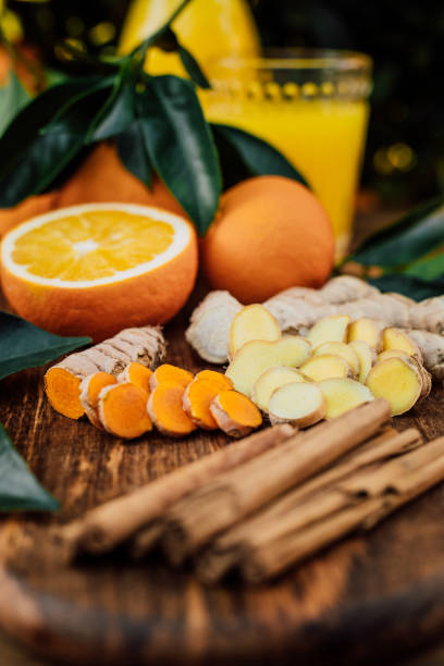istock Close-up of Turmeric and ginger root in slices with cinnamon sticks and freshly squeezed orange juice of untreated Bio oranges from the own garden 1284905128