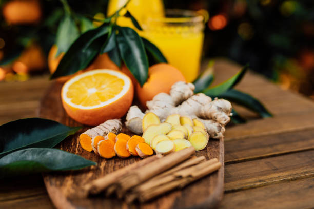 Turmeric and ginger root with cinnamon sticks and freshly squeezed orange juice of untreated Bio oranges from the own garden stock photo