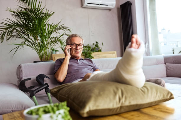 istock Senior man with broken leg at home 1284906320